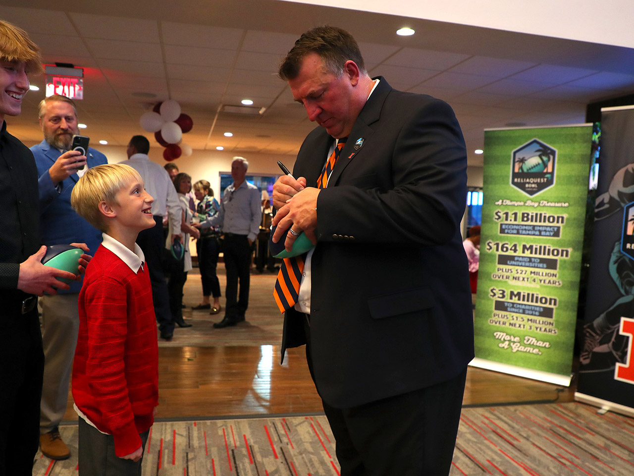 Bielema signs a football for a guest 